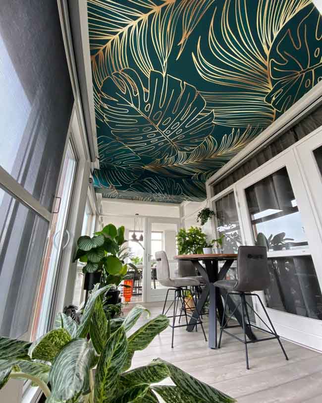 Papel pintado de hojas tropicales aplicado en un techo para una apariencia fresca y verde